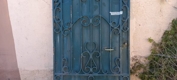 παλιά σιδερένια πόρτα με καράβολους και οβάλ αψίδα στο πάνω μέρος, μασίφ σε μπλε χρώμα, βαριά καγκελόπορτα, εξώπορτα κήπου,αυλόπορτα βαριά κατασκευή, χειροποίητη